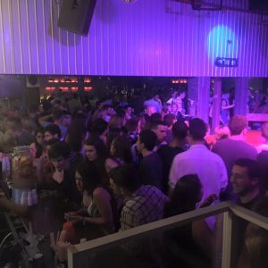 guy riding a mechanical bull surrounded by people watching