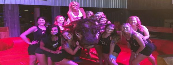 cowboy saloon employees taking a picture by a mechanical bull